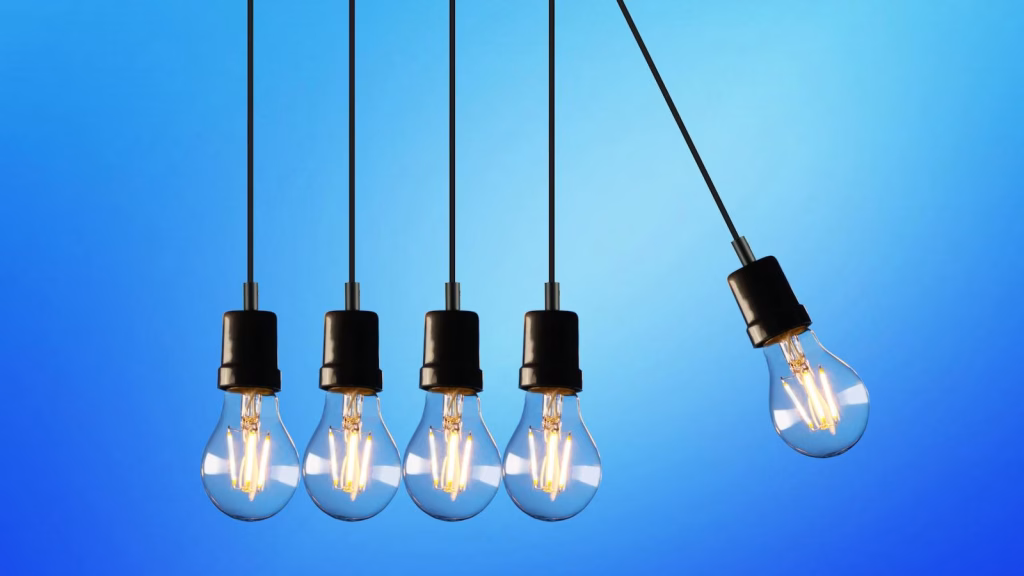 Hanging Edison-style light bulbs against a vibrant blue backdrop, showcasing energy and innovation.