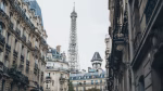 Scenic view of the Eiffel Tower framed by classic Parisian architecture on a charming street.