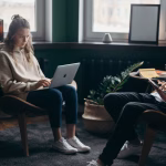 A couple working remotely in a stylish home office with plants and modern decor.